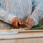 Une personne coupe des légumes sur une planche à découper