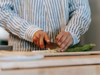 Une personne coupe des légumes sur une planche à découper