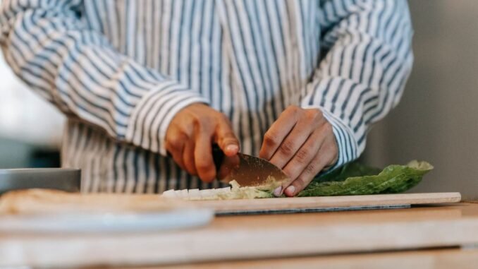 Une personne coupe des légumes sur une planche à découper