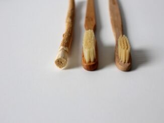 Trois brosses à dents en bois sur fond blanc