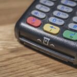 Un terminal de paiement noir avec clavier coloré sur bois
