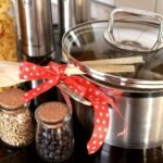Casserole en acier inoxydable avec couvercle, cuillère en bois et bocaux de légumes