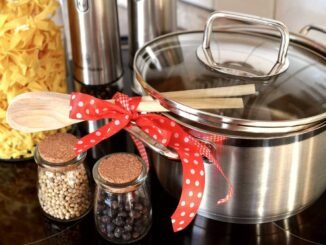 Casserole en acier inoxydable avec couvercle, cuillère en bois et bocaux de légumes